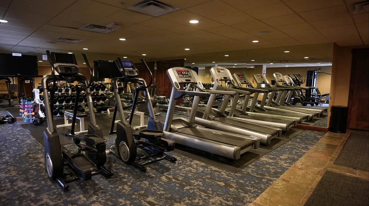 A bright, modern fitness center with treadmills, ellipticals, and a free weights section. The space looks clean, motivating, and well-equipped for guests interested in exercise and wellness during their stay.